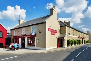 A two-story building with a sign for 'Hylands Burren Bar' and 'Hylands Burren Hotel' on the ground floor.