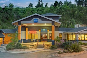 A Travelodge hotel with a registration desk, outdoor seating, and a landscaped entrance. - Travelodge Rapid City (Rapid City)