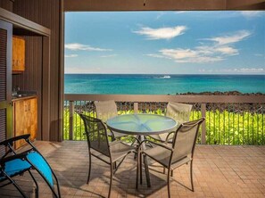 Enjoy the ocean view from this balcony with a round table and four chairs.