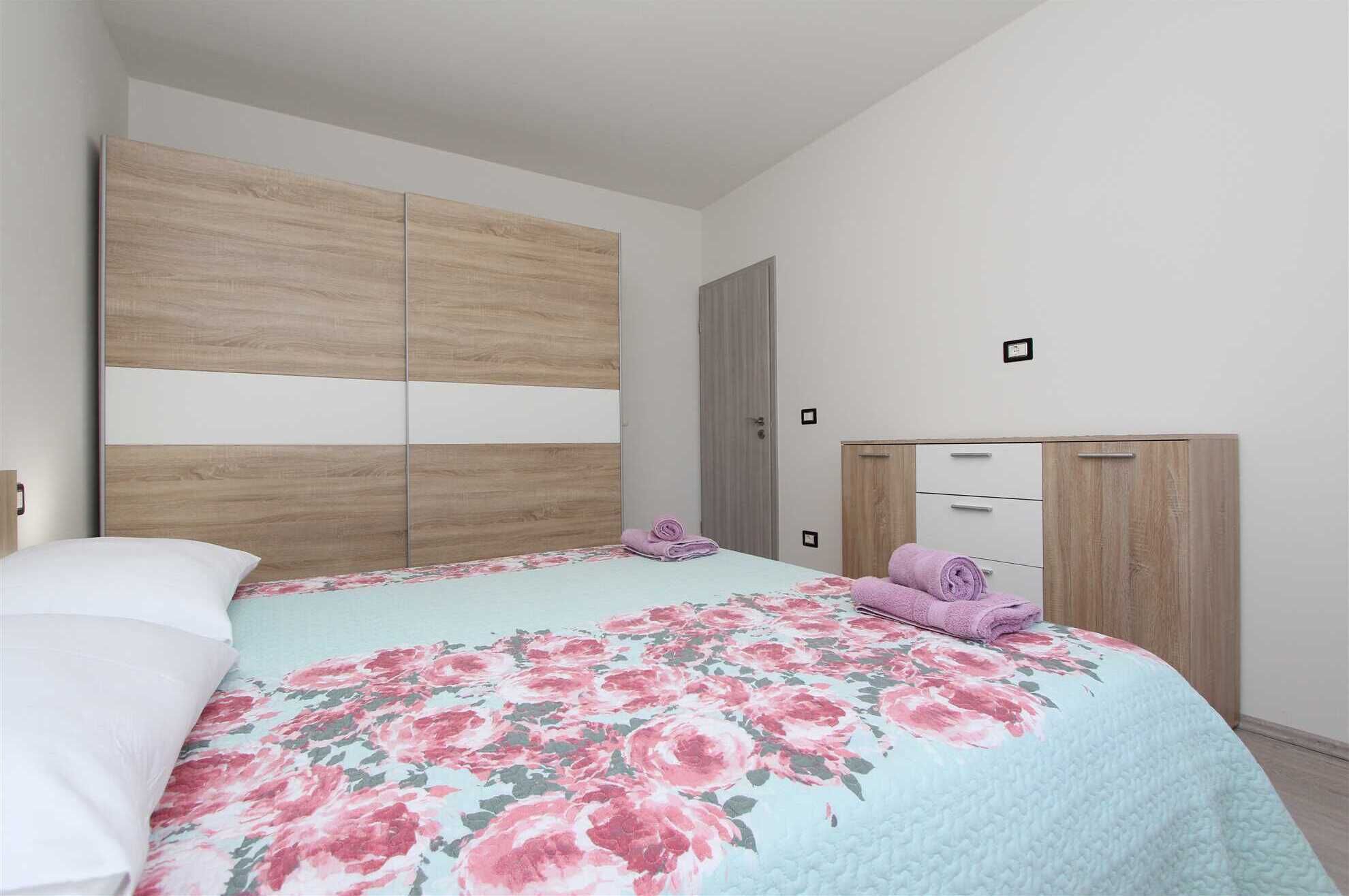 Ein Schlafzimmer mit einem Bett, einem Kleiderschrank und einer Tür.