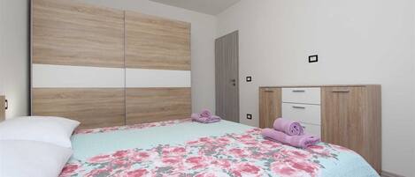 Ein Schlafzimmer mit einem Bett, einem Kleiderschrank und einer Tür.