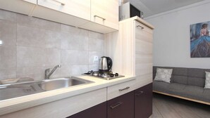 Een moderne keuken met een inbouwfornuis, een spoelbak en kastjes.