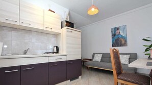 Een moderne keuken met een eethoek, een bank en een schilderij aan de muur.