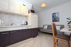 Une cuisine moderne avec un coin repas, un canapé et un tableau accroché au mur.