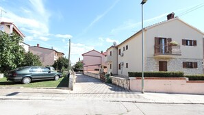 Une rue résidentielle bordée de maisons, avec une voiture garée et un ciel dégagé.