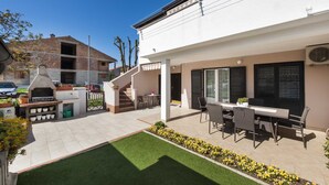 A modern house with a patio, outdoor seating, and a barbecue area. - PATAJ One-Bedroom Apartment with Terrace 3 (Rovinj)