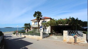 Ein Küstengebäude mit Balkon, Garage und Meerblick.