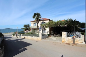 A coastal building with a balcony, a garage, and a view of the sea.