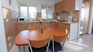 Eine moderne Küche mit einem Holzespeisetisch, weißen Schränken und einer Mikrowelle.