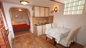 Une petite chambre comprenant un lit, une kitchenette et une fenêtre.