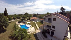 A two-story house with a swimming pool, surrounded by trees and a clear sky. - VILLA FJORD One-Bedroom Apartment 1 (Kanfanar)
