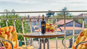 A balcony with a table set for two, featuring a bottle of wine, glasses, and a bowl of fruit. - VILLA FJORD One-Bedroom Apartment 1 (Kanfanar)