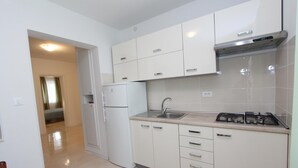 A modern kitchen with white cabinets, a built-in stove, and a sink. - PALAZIOL Two-Bedroom Apartment 1 (Rovinj)