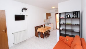 Un espacio habitable pequeño con comedor, kitchenette y sofá.
