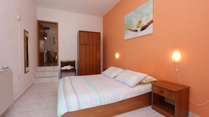 Un dormitorio con cama, mesita de noche y un cuadro en la pared.