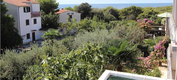 A residential area with houses, greenery, and a view of the sea.