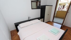 A bedroom with a bed, a desk, a chair, a wardrobe, and a window. - LORA One-Bedroom Apartment 3 (Rovinj)