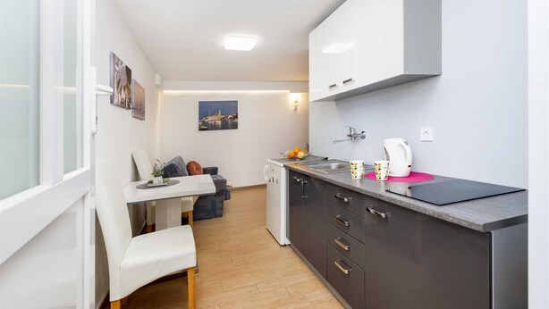 A compact kitchen with a dining area, a small refrigerator, and a coffee maker. - SILVANA One-Bedroom Apartment with Terrace 2 (donji) (Rovinj)