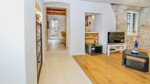 Ein modernes Wohnzimmer mit Holzboden, einem Fernsehschrank und einer Steinwand.