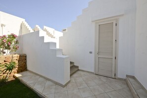 A white exterior with a door and a small set of stairs leading to a tiled area. - Blue Sea Villa Maestrale by Wonderful Italy (Ostuni)
