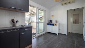 Eine moderne Küche mit dunklen Schränken, einem eingebauten Herd und einem großen Fenster.