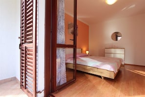 Relax in this inviting bedroom with a comfortable bed, mirror, and natural light.