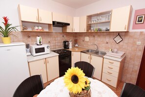 Enjoy meals at the dining table for two, equipped with a stove, sink, and microwave.