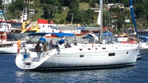 A large yacht docked at a marina with other boats, surrounded by buildings and greenery. - Yacht Yota Bellavita (Gros Islet)