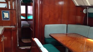 A compact, wooden interior with a dining table and cushioned seating. - Yacht Yota Bellavita (Gros Islet)