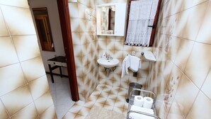 Ein Badezimmer mit Waschbecken, Spiegel, Handtuchhalter und einer Duschkabine.