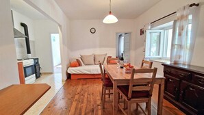 A cozy living space with a dining area, a sofa, and a kitchen. - GINA Two-Bedroom Apartment (Bale)