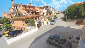 A residential street with houses, a parked car, and a clear sky. - EMANUEL Studio with Balcony 3 (Rovinj)