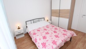 A bedroom with a bed, a nightstand, a wardrobe, and a bedside lamp. - PALAZIOL Two-Bedroom Apartment 2 (Rovinj)