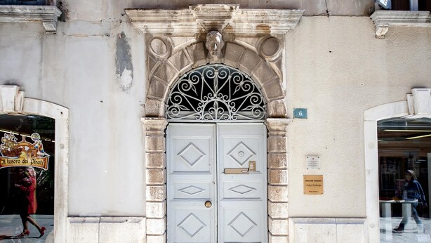 A building entrance with a white door, decorative metalwork, and a plaque. - BAROCCO One-Bedroom Apartment (Rovinj)