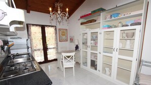 A kitchen with a gas stove, a sink, a chandelier, and a cabinet with storage boxes. - APOLLONIO Studio Apartment with Terrace (Rovinj)