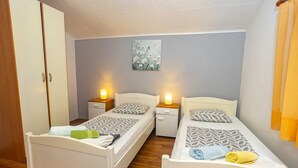 A small, well-lit bedroom with two single beds, each with a bedside table and lamp. - VILLA FJORD Two-Bedroom Apartment 4 (Kanfanar)