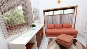 Un salon moderne avec un bureau blanc, un canapé et une grande fenêtre avec des rideaux.