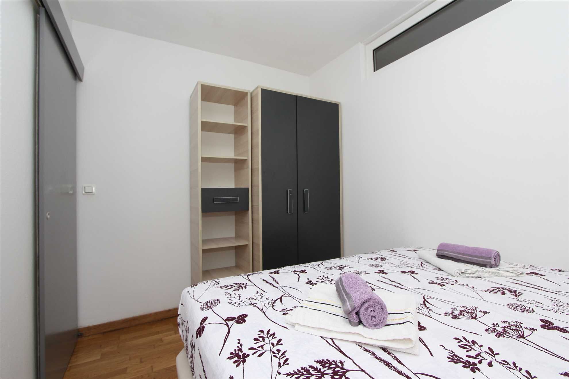 Een slaapkamer met een bed, een kledingkast en een inbouwkast.