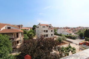 Un barrio residencial con edificios de varios pisos, balcones y cielo despejado.