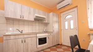 A kitchen with white cabinets, a built-in oven, and a sink. - RAJCI One-Bedroom Apartment 2 (plavi) (Rovinj)