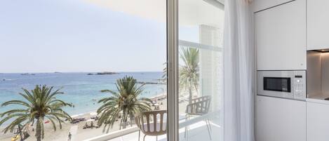 A modern kitchen with a large window overlooking a beach.