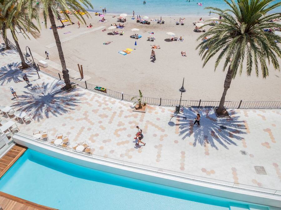 Une vue sur la piscine, avec une plage et l’océan en arrière-plan.