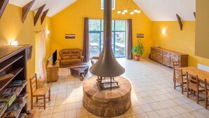 A spacious living area with a fireplace, a dining table, and a sofa.