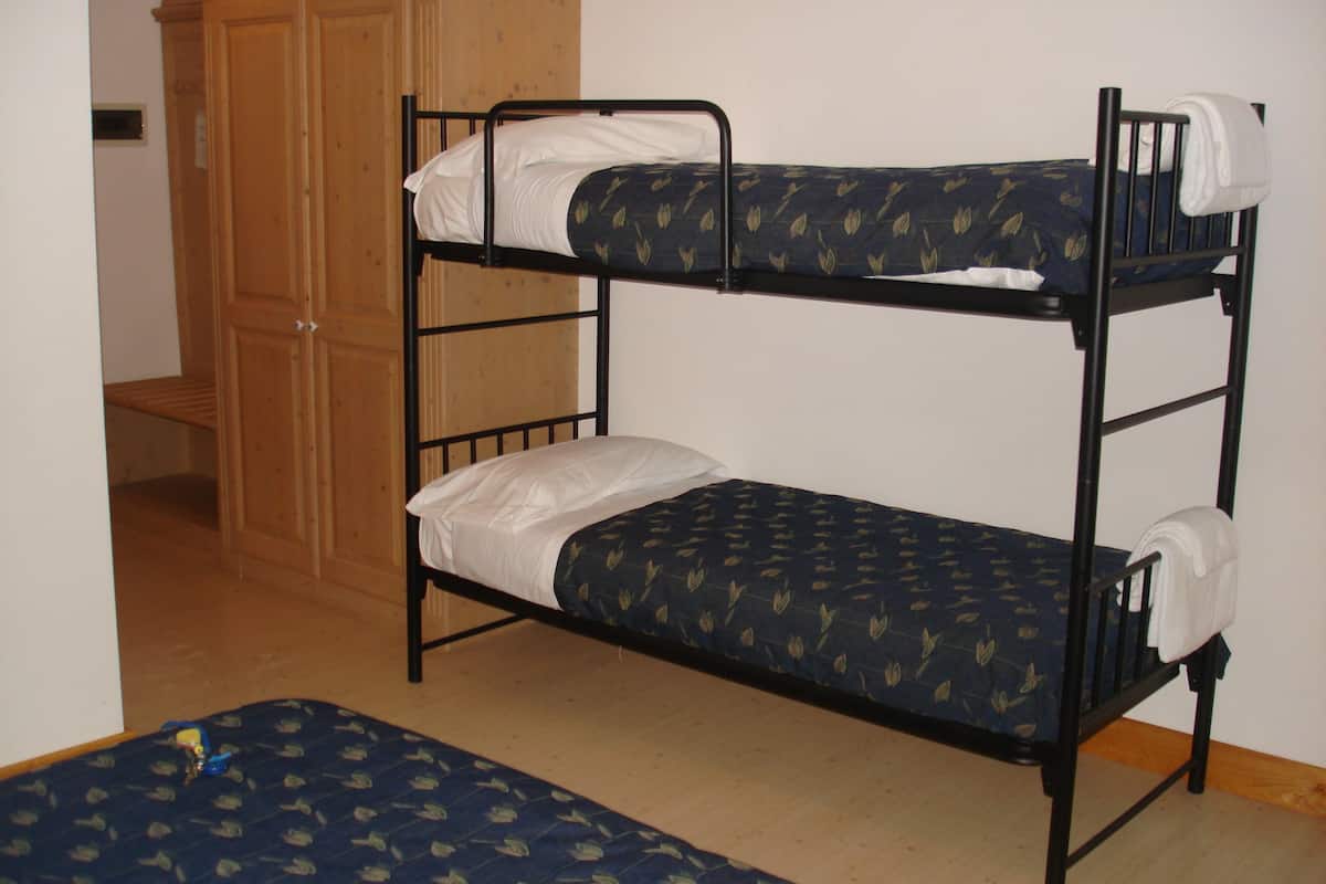 A bunk bed with a lower bunk and a mattress on the floor.