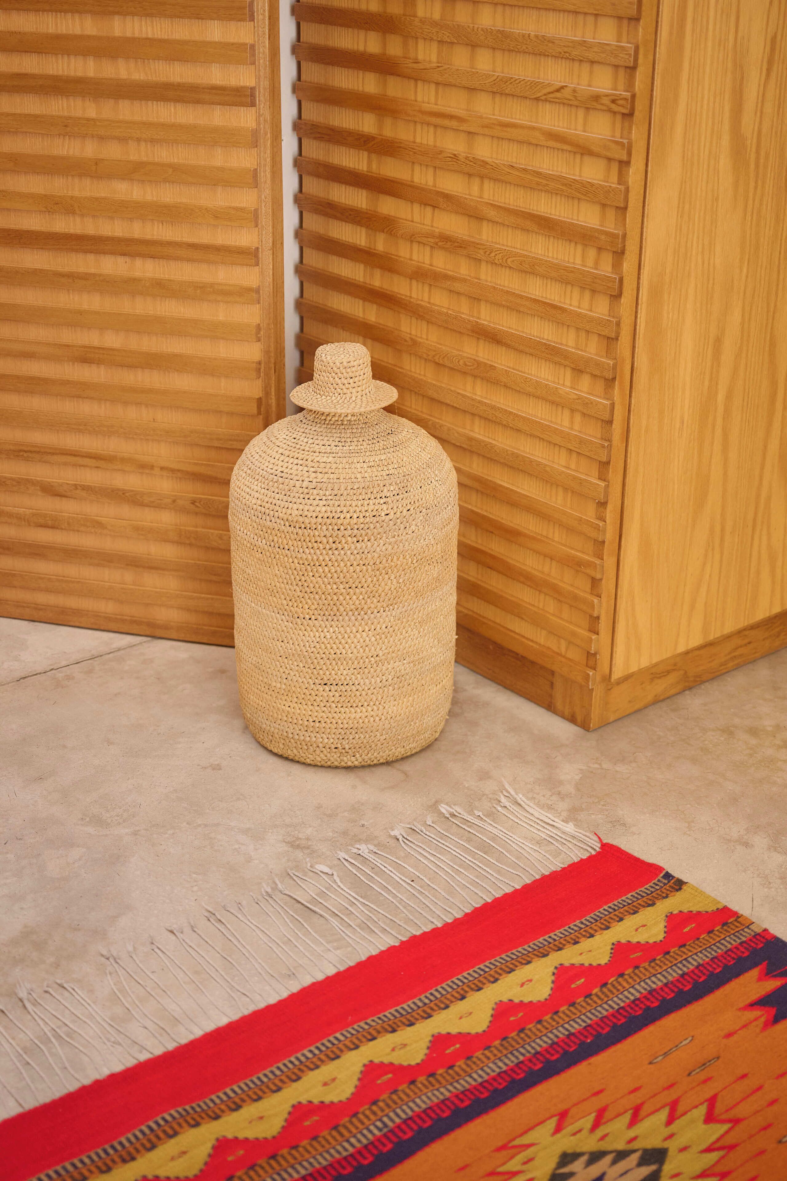 A woven basket in a corner, a patterned rug, and wooden paneling.