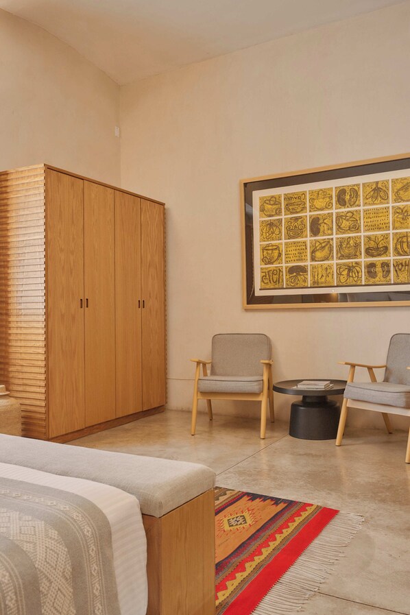 A room with a bed, a wardrobe, two chairs, a small table, and a framed artwork on the wall. - Casa Carmen Morelos (Oaxaca)