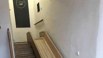 A wooden bench with a metal frame, a wooden floor, and a wall-mounted sign.
