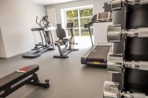 A gym with exercise equipment including treadmills, stationary bikes, and weight machines.