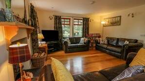 A living room with a sofa, a television, and a lamp. - Thistle Dhu (Newtonmore)