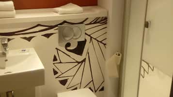 A bathroom with a white sink, a toilet, and a shower area.